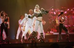 Madonna performing on stage with background dancers and singers