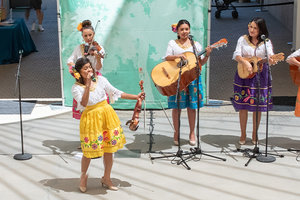 Photo of Las Calibri standing in the Skirball Amphitheater performing with instruments