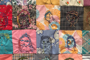 Photo of many colorful squares of fabric sewn together. Thread is sewn in each square to create &quot;faces&quot; with lines