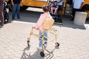 Students with mobility devices getting off a school bus