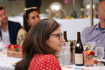 A photo of people gathered at a table outside for a meal