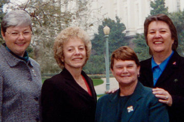 Photo of activists Carole Migden, Sheila Kuehl, Jackie Goldberg, and Christine Kehoe standing together in a green park