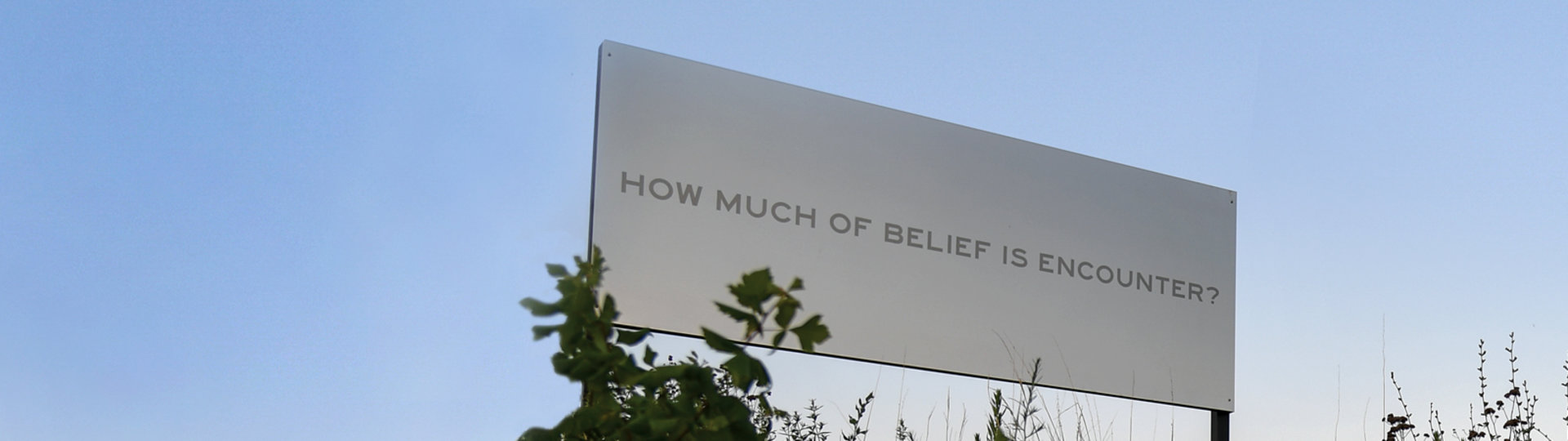 Outdoor art billboard by Chloe Bass that reads, "How much belief is encounter" 