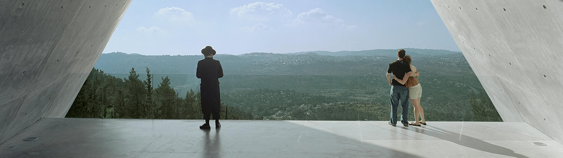 Hasidic Jew and a man and woman holding each other at Yad Vashem