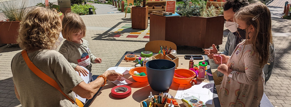 Photo of a family at a craft table outside at the Skirball