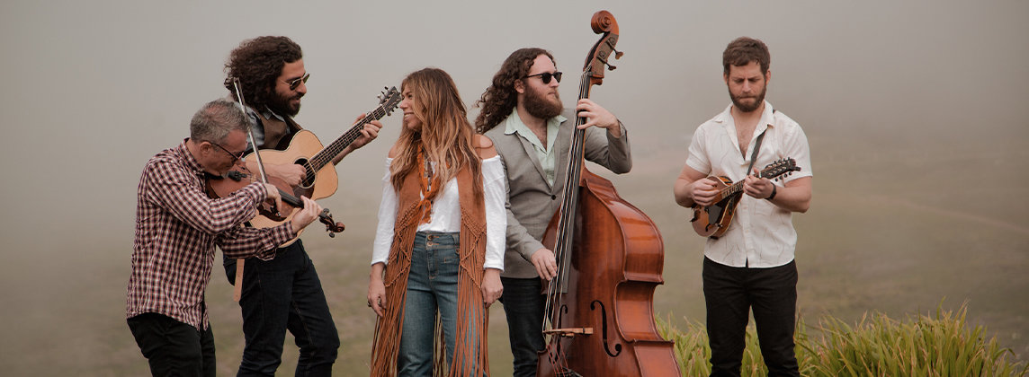 Photo of the band Nefesh standing outside on a hilltop playing their instruments