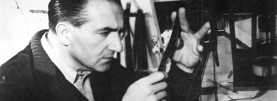 Black and white close-up of Director Fritz Lang inspecting a strip of film