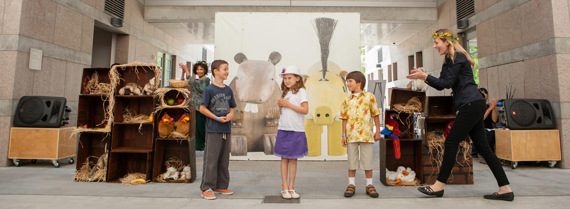 children standing in a line with adults clapping to music