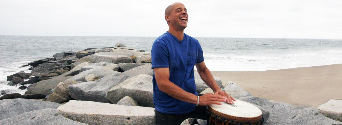 smiling man playing a drum