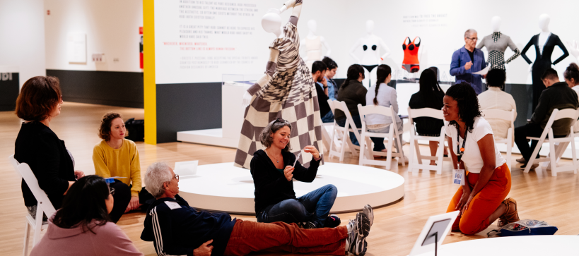 people sitting on the floor and in chairs having a discussing