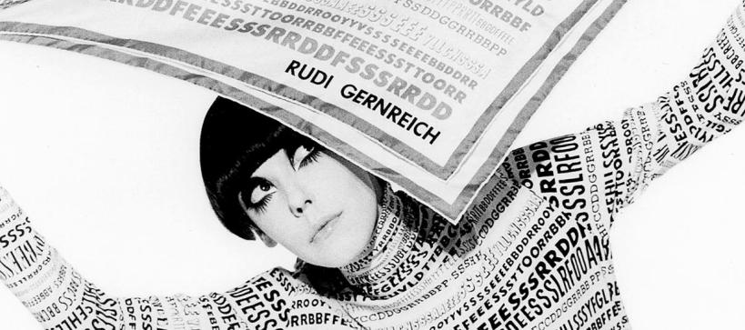 woman with large painted eyebrows and eyelashes holding a piece of paper above her head