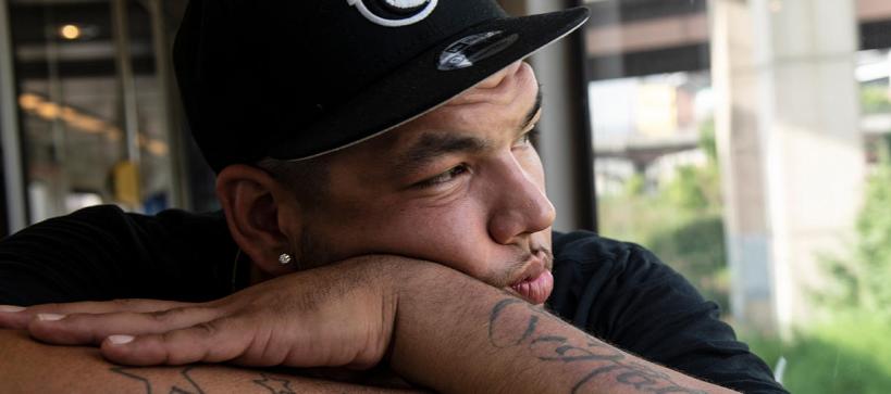 close-up of a young man in a baseball cap staring off into distance