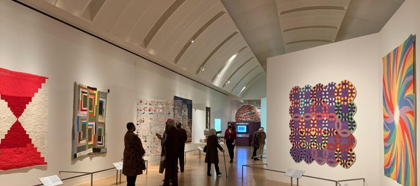 Installation photo of Fabric of Nation exhibition with visitors in gallery