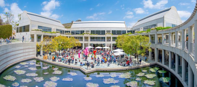 Wide angled image of courtyard during puppet festival with colorful puppets and visitors celebrating form a distance