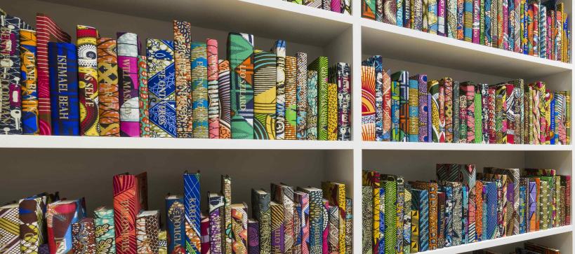 Close up view of colorful books on white shelves