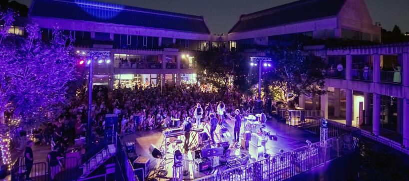 A concert in a courtyard at night with a full audience.