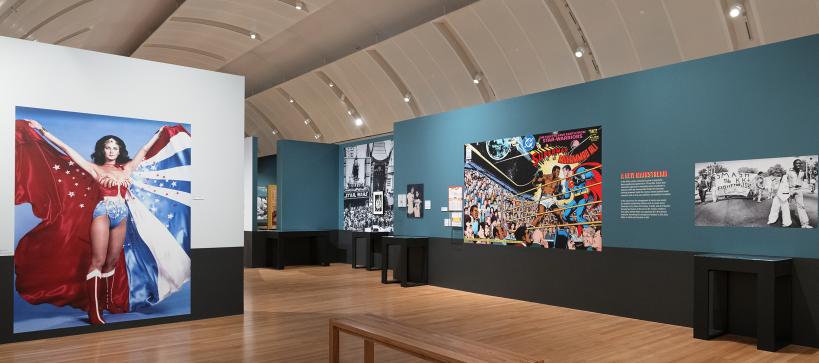 A wide gallery shot with a large mural of Wonder Woman and another with Superman.
