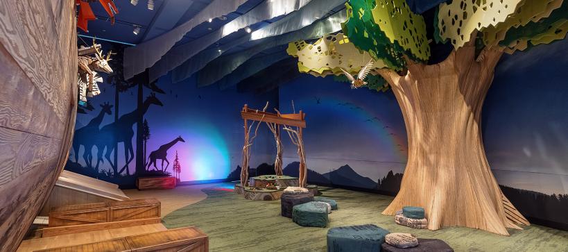 A wide shot of a giant wooden tree next to an ark in a gallery.