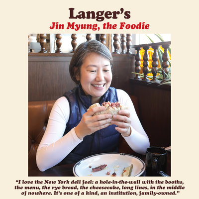 Photo of diner at Langer's holding up a pastrami sandwich