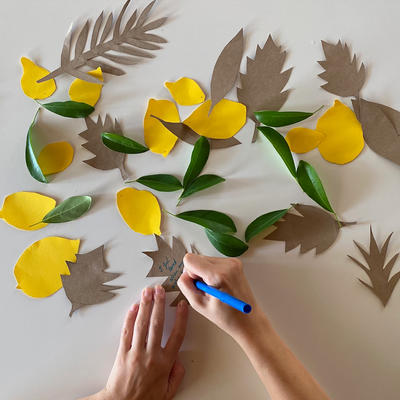 Paper leaves and lemon cutouts strewn across a surface