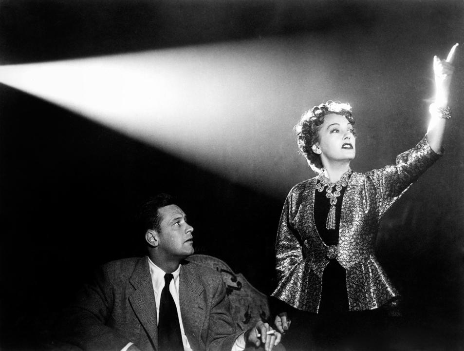a man sitting and a woman standing next to him