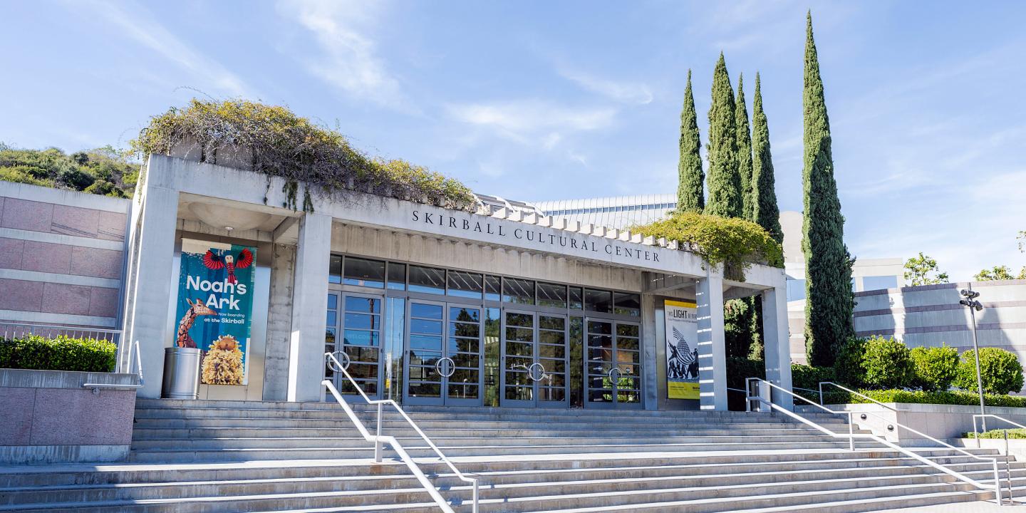 Front entrance to The Skirball Cultural Center, stairs that lead up glass doors.