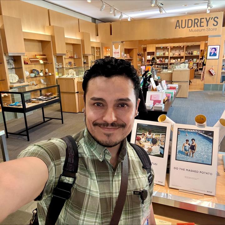 A man takes a selfie inside a museum store
