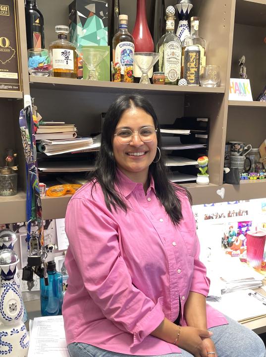 Woman stands in front of desk