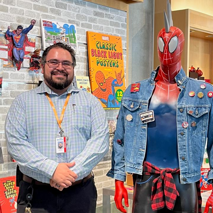 A man stands beside a Spiderman mannequin