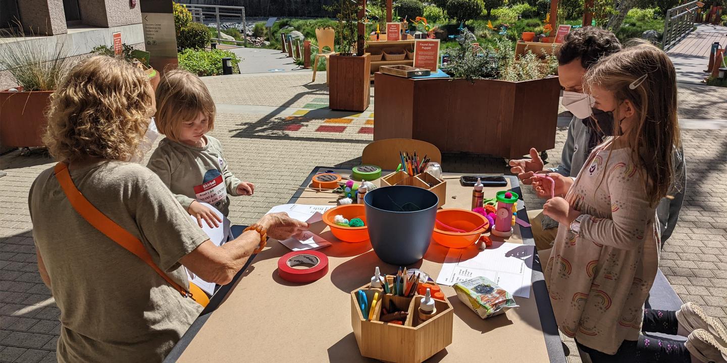Photo of a family at a craft table outside at the Skirball
