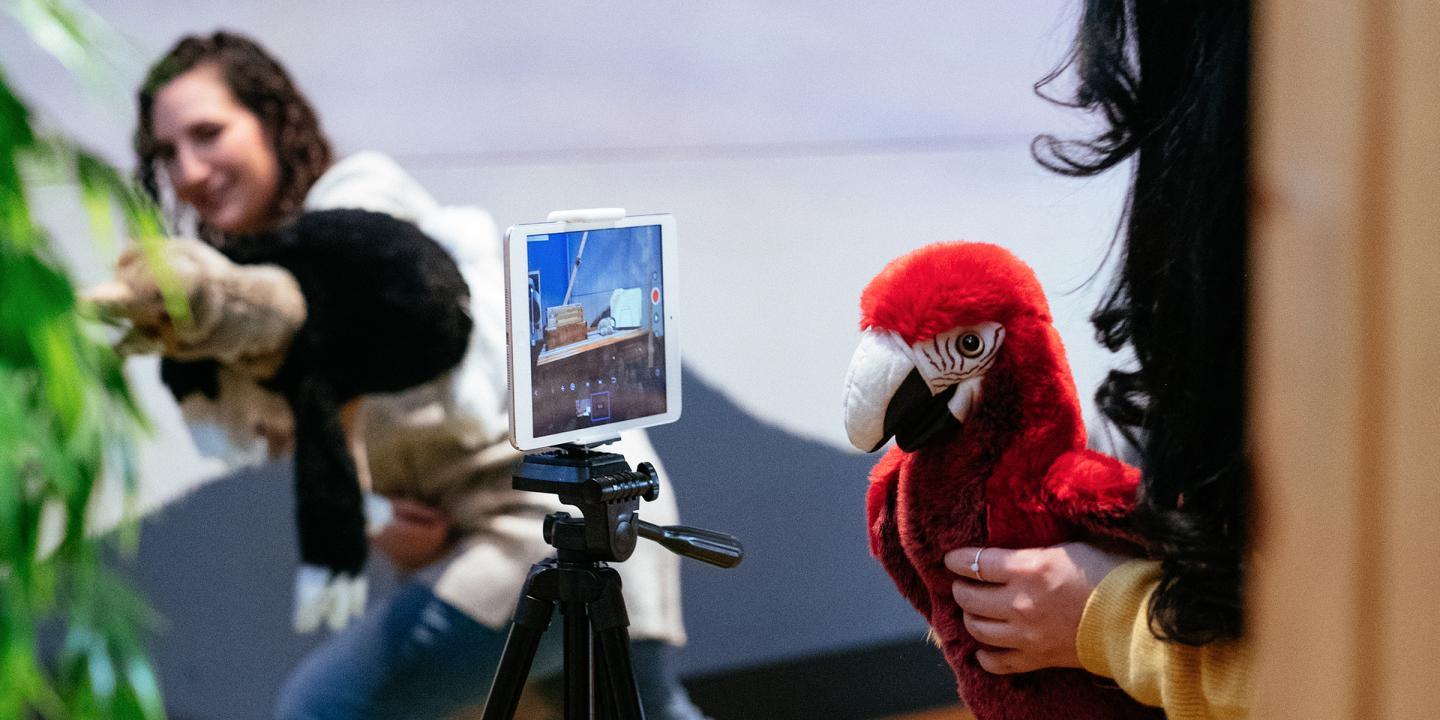 Two educators filming a story with bird puppets in the Noah's Ark gallery