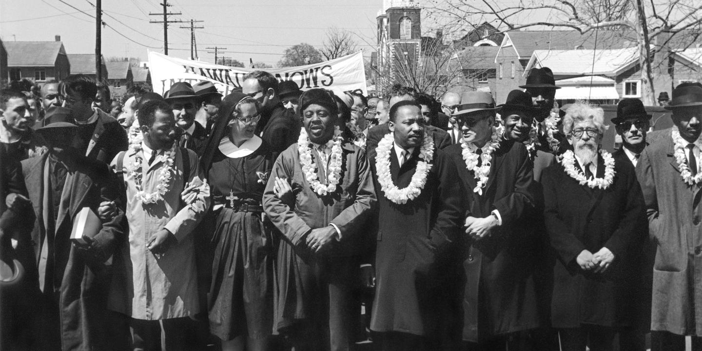 A row of people lead marchers