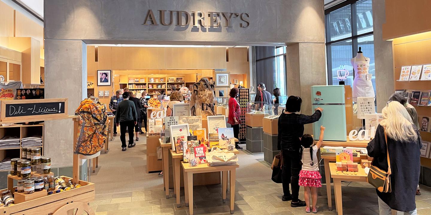 A store setting with books and gift with many people browsing.