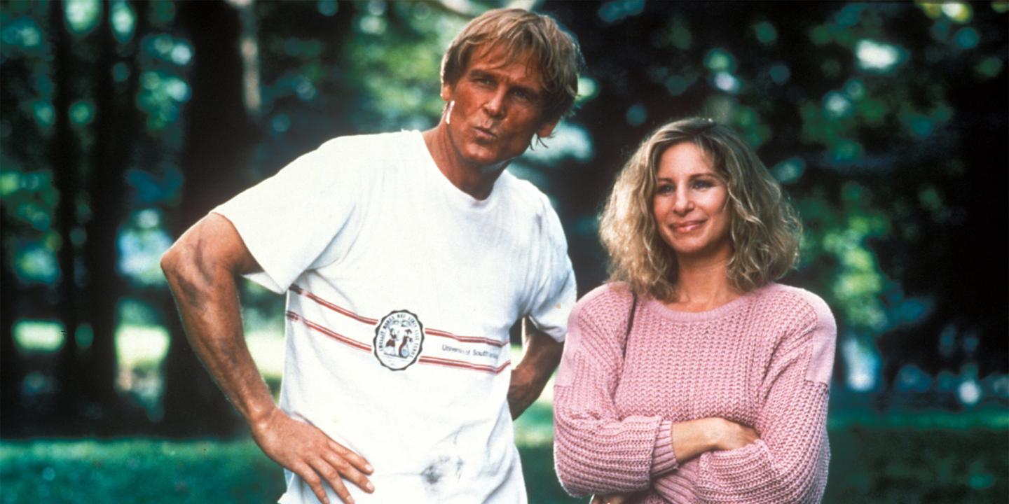 Still from the movie showing Nick Nolte and Barbara Streisand standing side-by-side looking towards the camera in a park