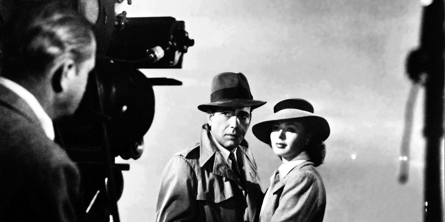 Behind the scenes still from the film, Casablanca, showing a camera operator filming Rick and Ilsa making their farewell on the runway of the airport.