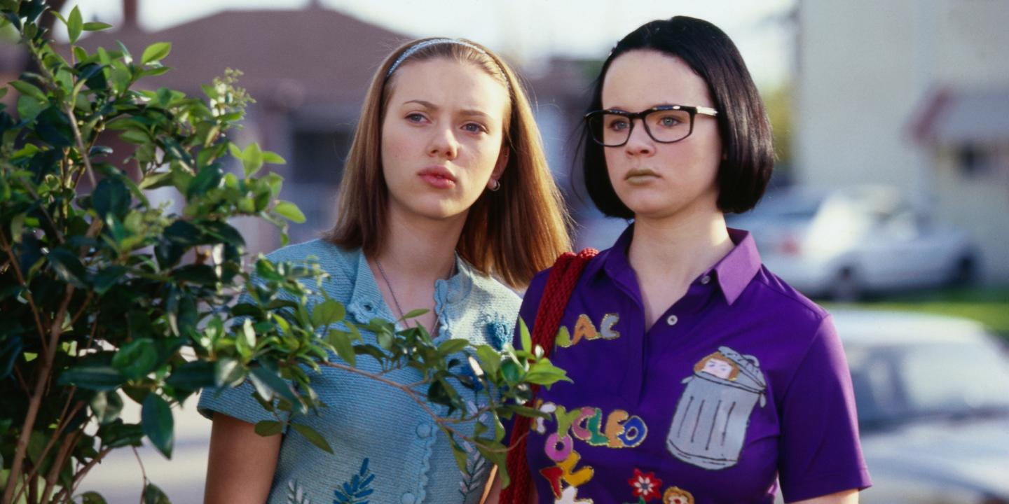 Still from the film Ghost World showing Scarlett Johansson and Thora Birch standing side by side looking at something off camera.