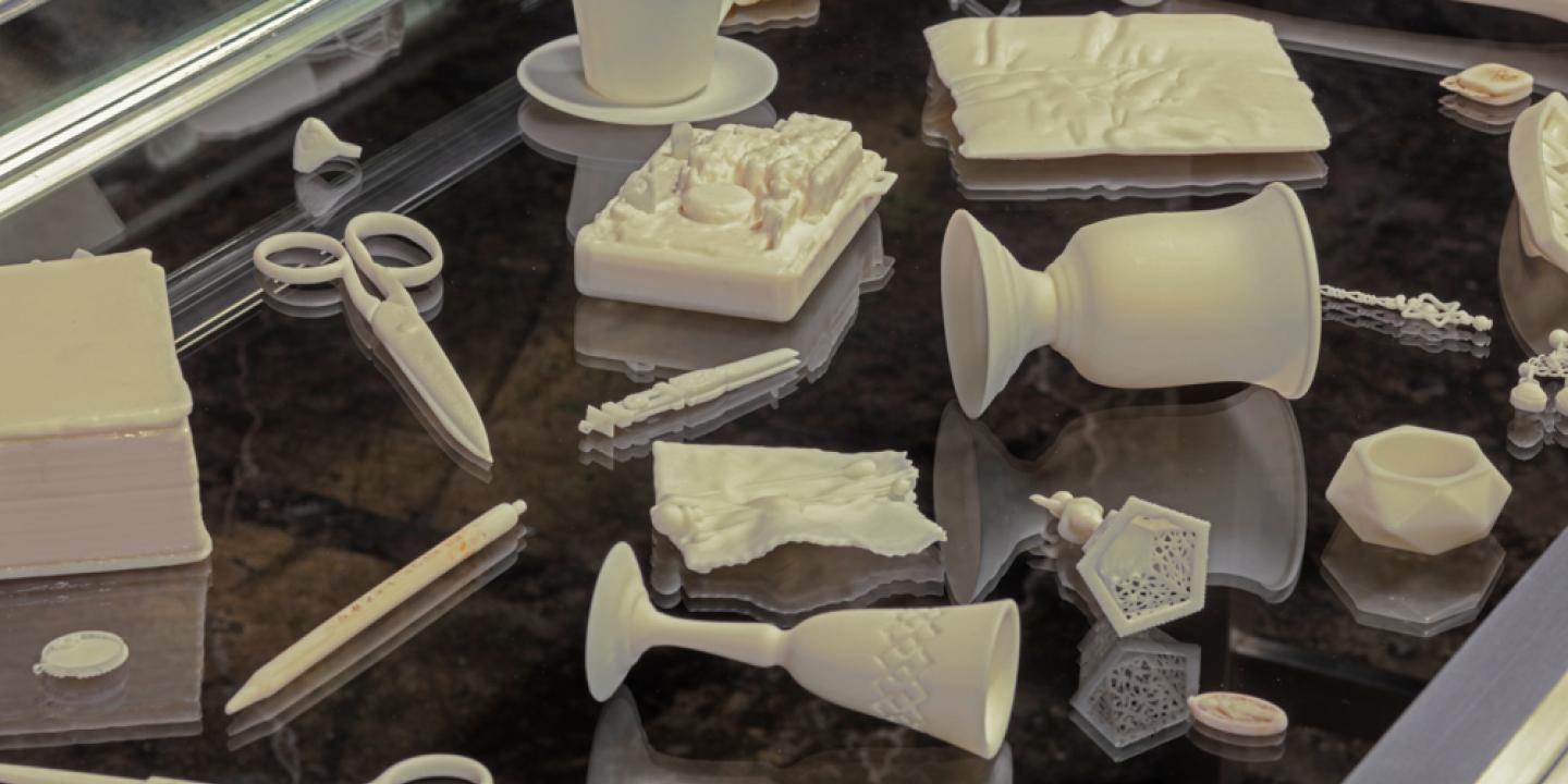 An assortment of white objects including scissors and cups are laid across a black table.