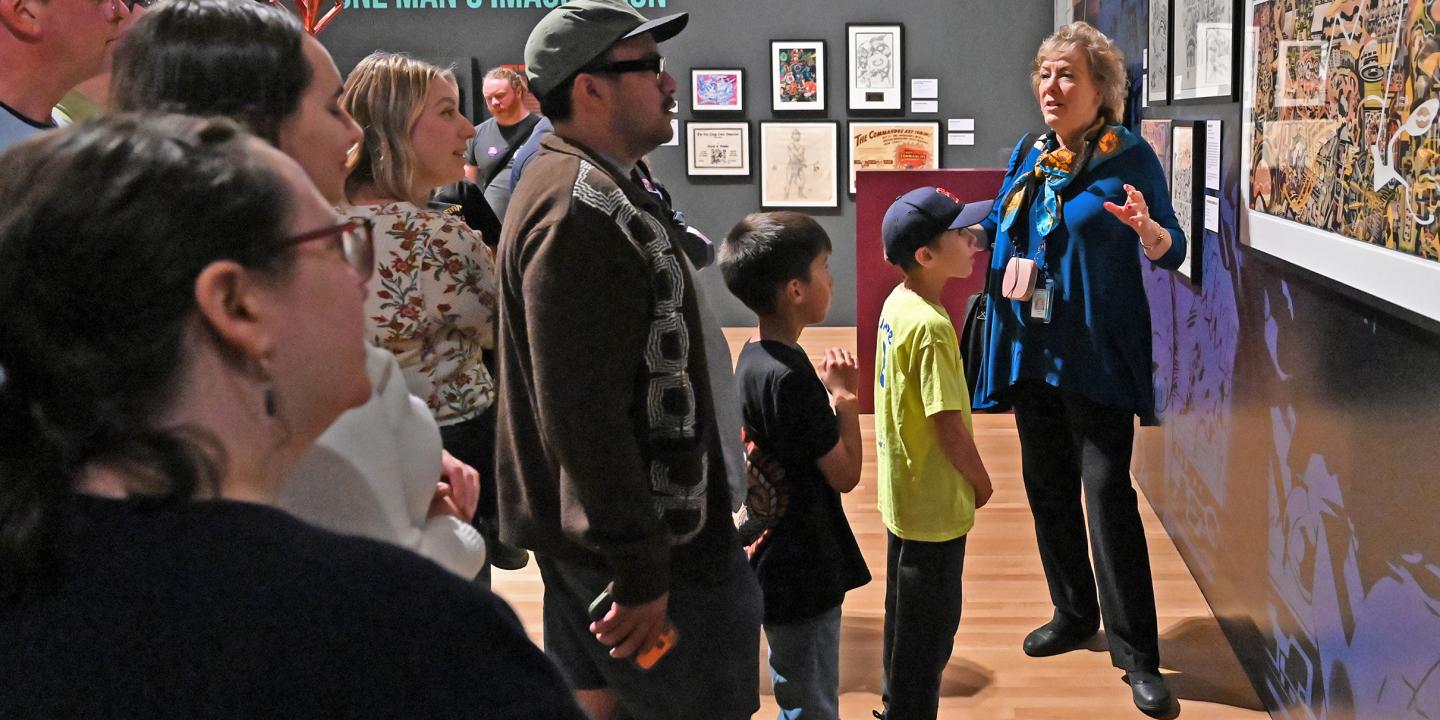 A teacher talked to a school group about comic books as they listen to her.