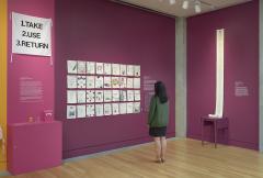 woman looking at fabric samplers on exhibit wall