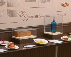 display showing plastic versions of deli food: bagel with lox and cream cheese, cheese cake; matzoh ball soup