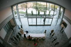 Ruby Foyer view looking down from above showing a long table with name cards arranged on it and people gathered around