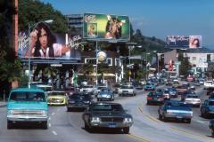 view of several billboards for Eddie Money, Cher and Judy Collins along Sunset Blvd