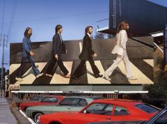 billboard for the Beattles showing them walking in a line in a crosswalk