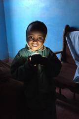 a young smiling girl shines a light on her face