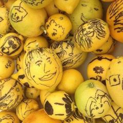 a bunch of lemons with drawing of faces on them
