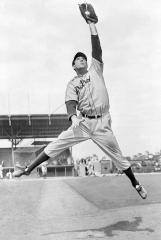 baseball player jumping up and catching a ball in his mitt