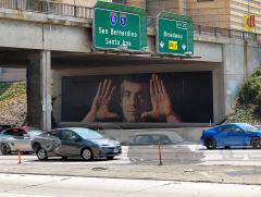 mural under a freeway overpass showing a man holding up his hands