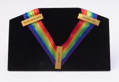 rainbow-colored ribbon with 3 badges that say 'Kennedy Center Honor, Paul Simon, December 8, 2002'