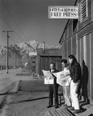 three men holding newspapers standing outside a building with a sign that says 'Office of Reports Free Press'