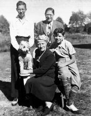 group photo of 4 people and a dog